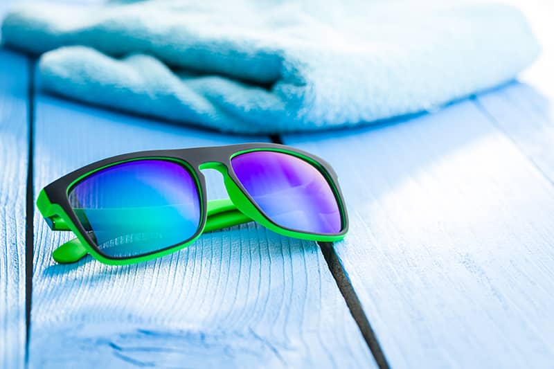 Sunglasses next to a beach towel