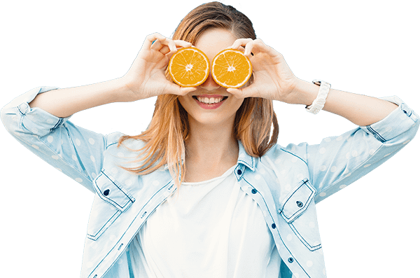 Woman posing holding orange slices in front of her eyes
